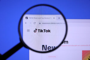 Homepage of TIKTOK Website magnified on logo with magnifying gla