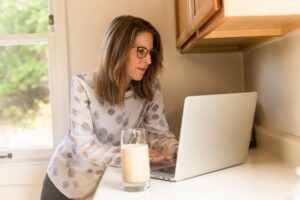 vrouw met laptop in de keuken